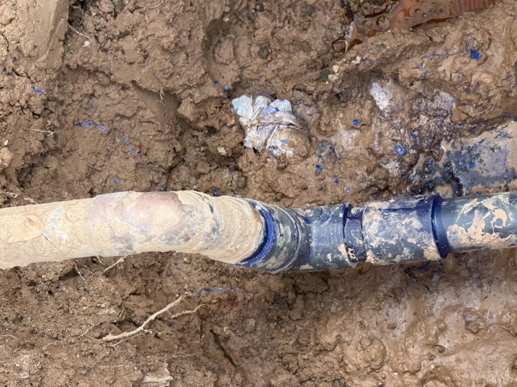 Close-up of repaired 2-inch irrigation main line connection at Acero Hawes Crossing